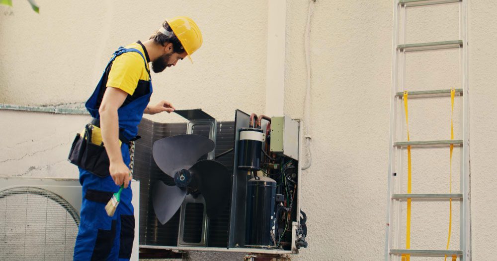 Technician inspecting an outdoor air conditioner unit.